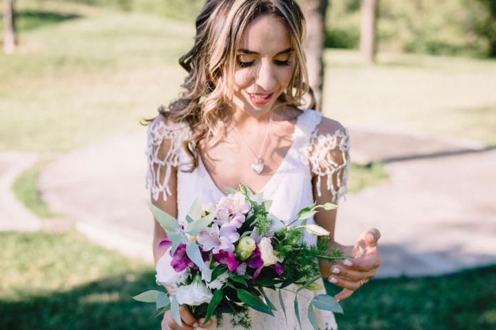 novia con peinado con ondas sosteniendo ramo de flores