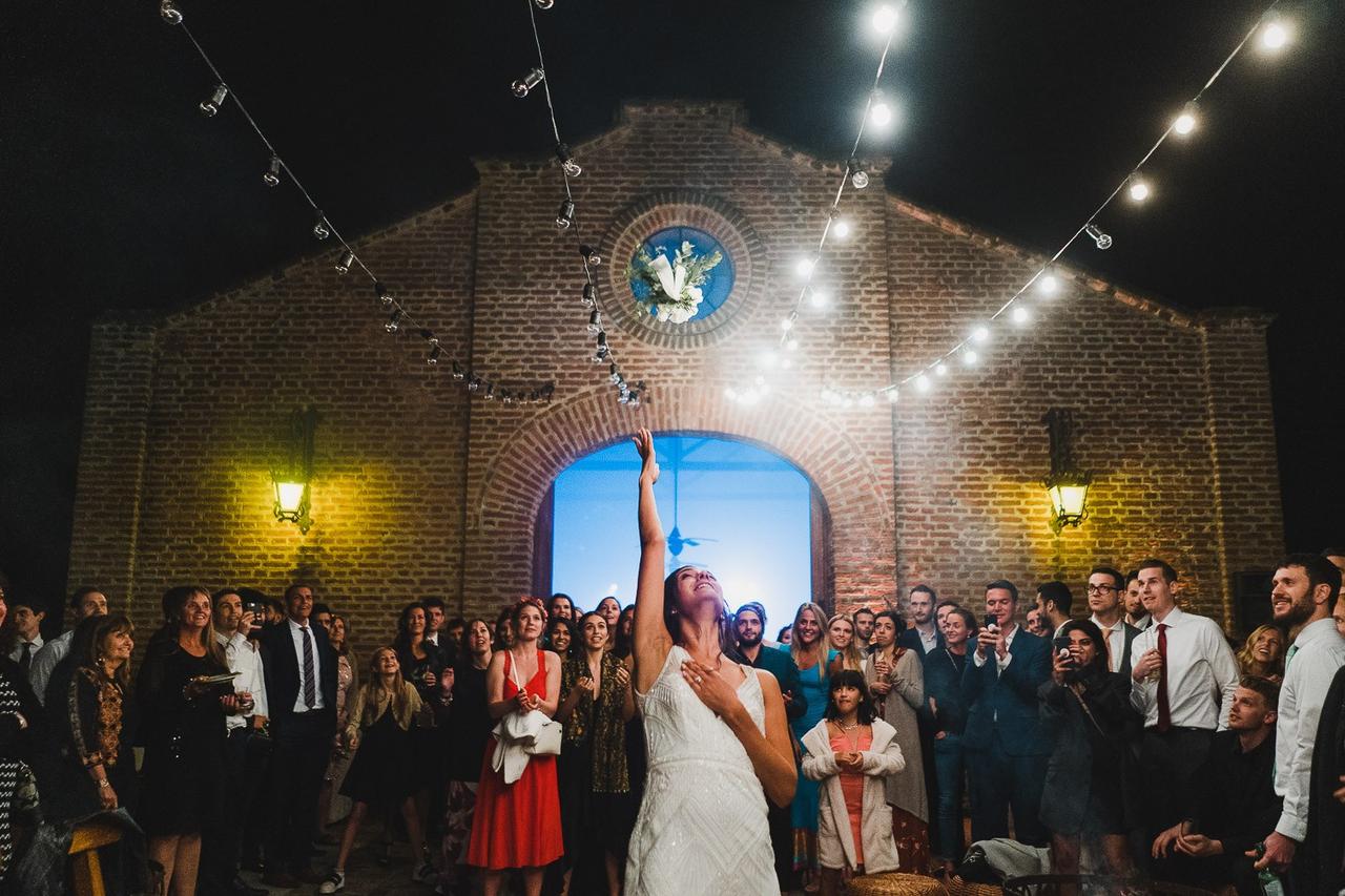 novia tirando el ramo a las amigas en la fiesta de casamiento