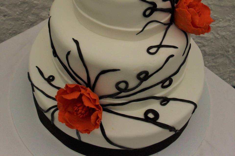 Torta blanca con negro y flores naranjas