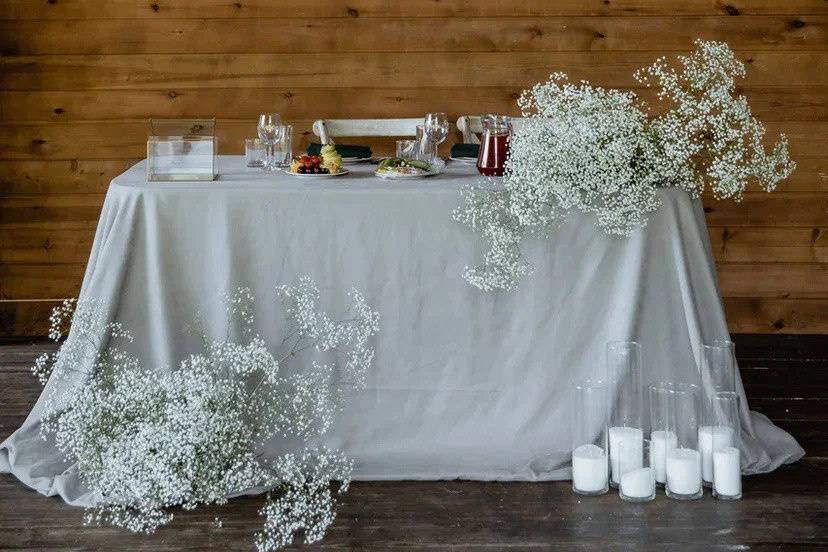 Mesa decorada con velas y flores blancas