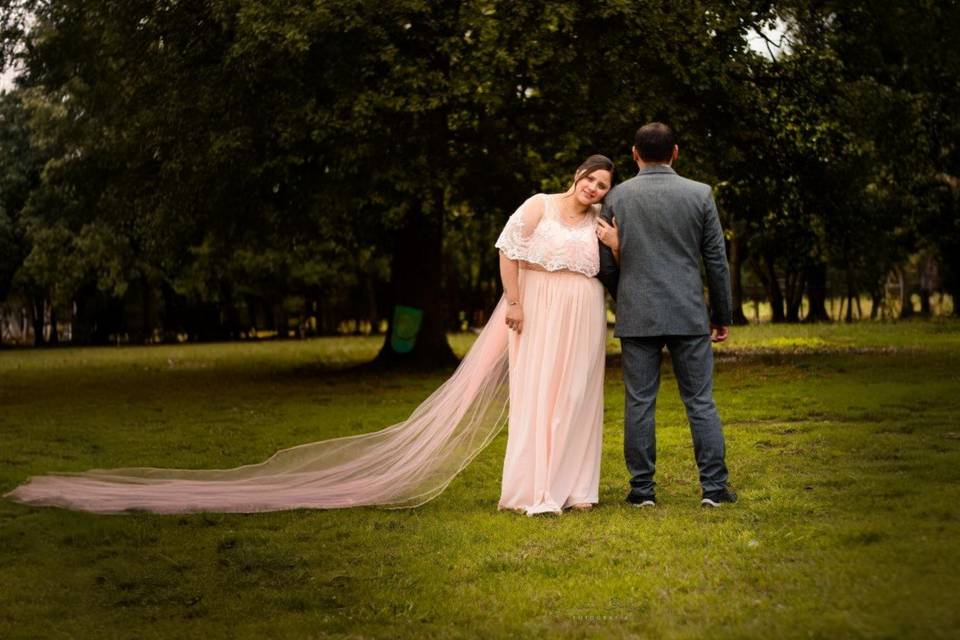 Novia mirando hacia el frente y novio de espaldas en un jardín