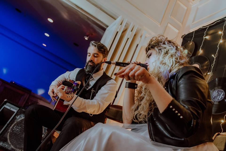 Mujer cantando junto a guitarrista