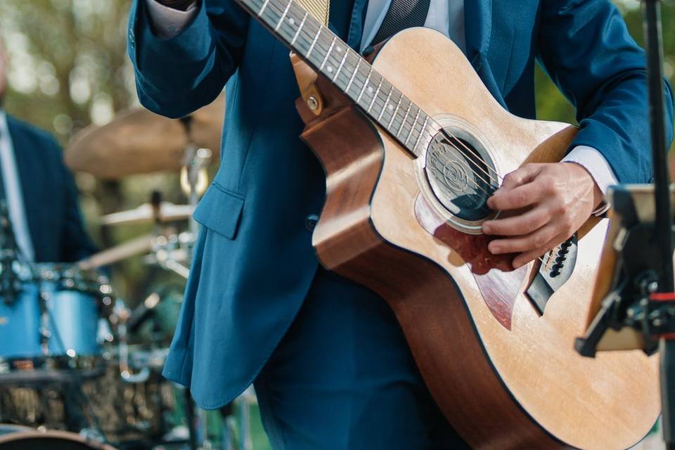 Cantante en traje azul tocando la guitarra