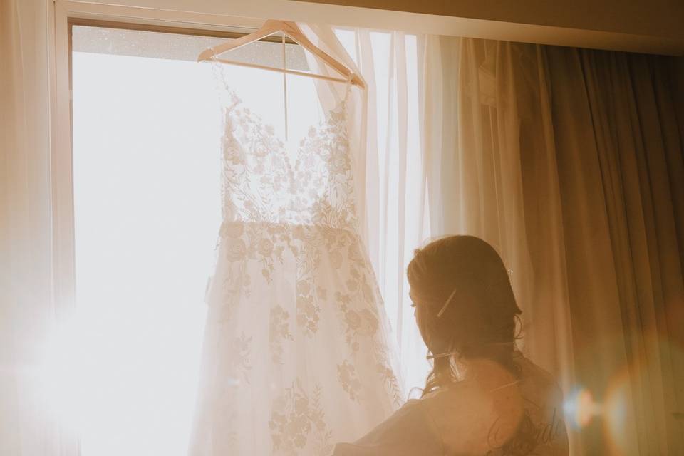 Novia viendo su vestido en la ventana