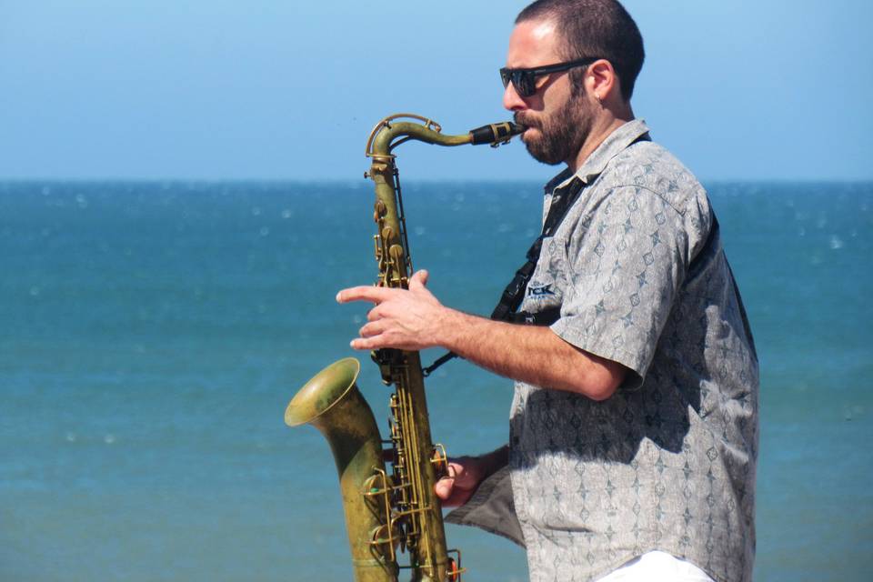 Saxofonista tocando frente al mar