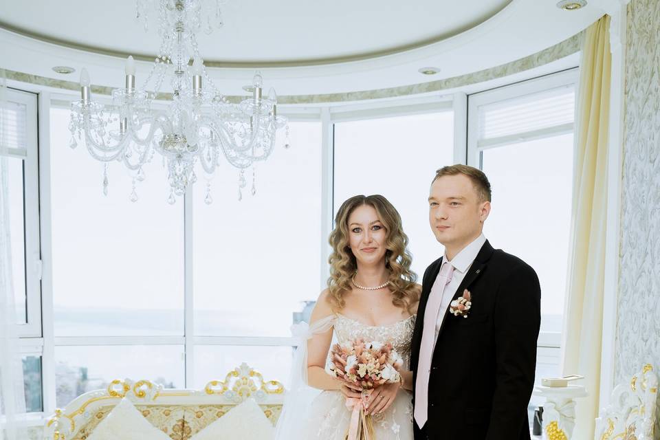 Novios posando en una sala blanca