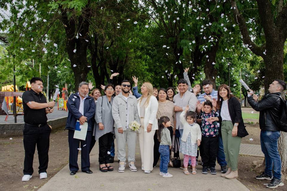 Pareja con invitados posando en un parque