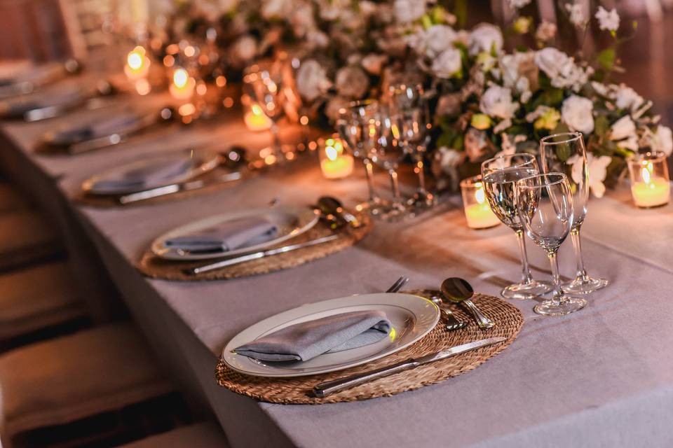 Mesa decorada con velas y flores blancas