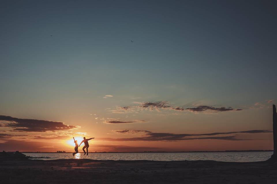 Pareja jugando en el mar al atardecer