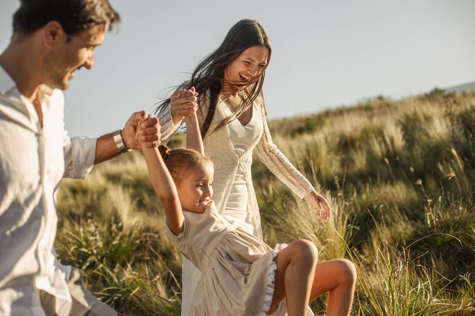 Pareja jugando con su hija en el campo