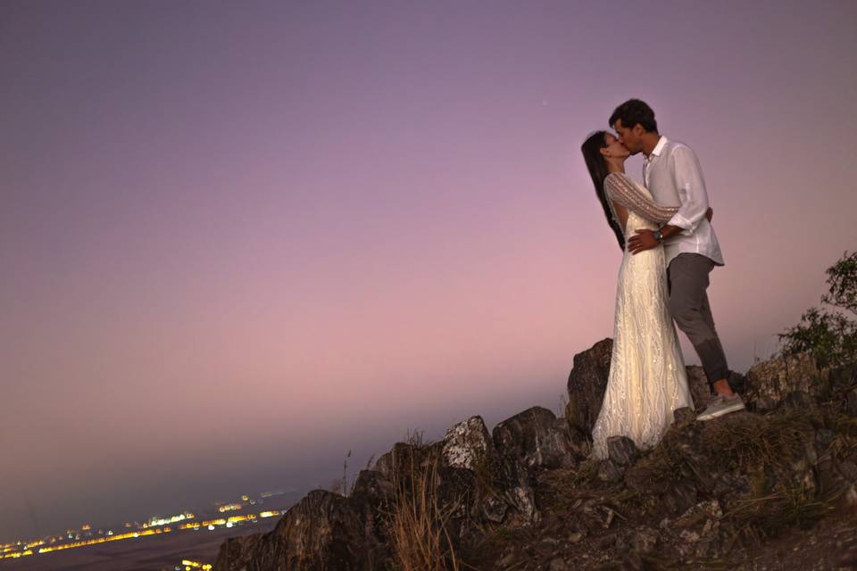 Novios besándose en un mirador al atardecer