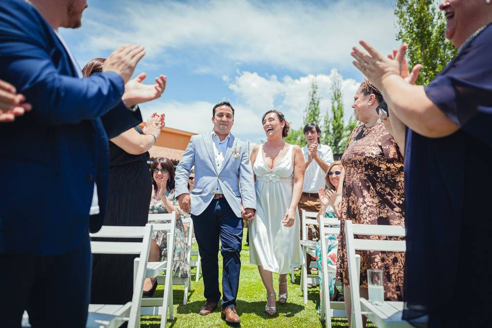 Novios caminando en medio de sus invitados