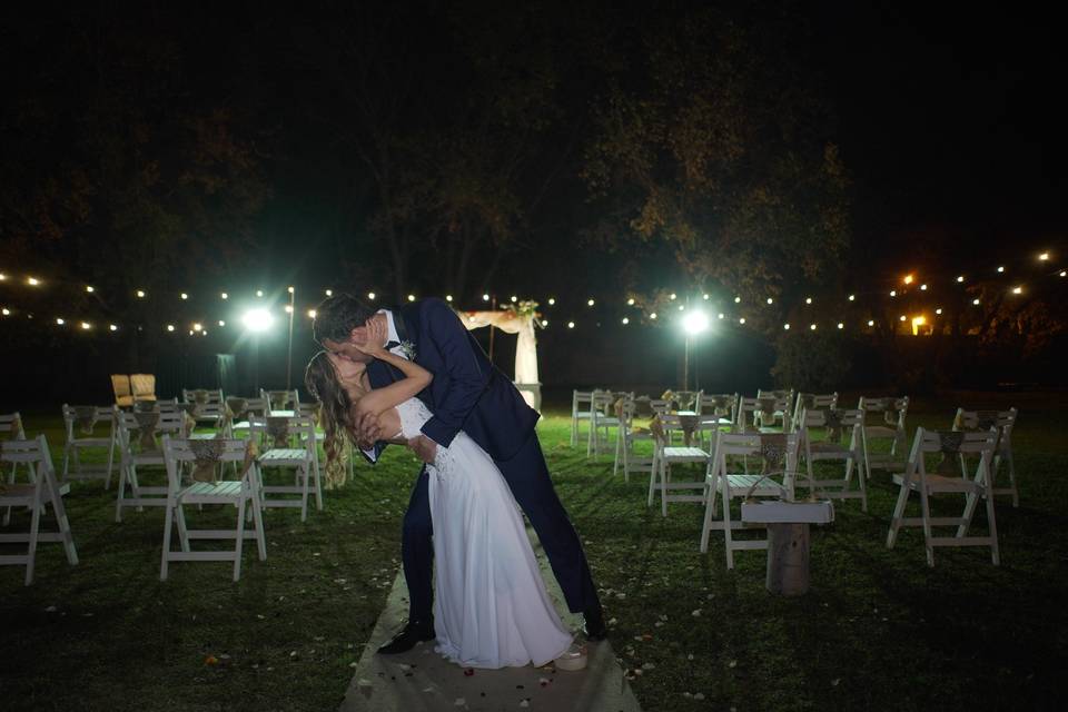 Pareja besándose en el jardín de noche