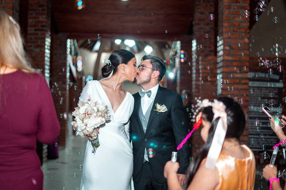 Novios besándose frente a sus invitados