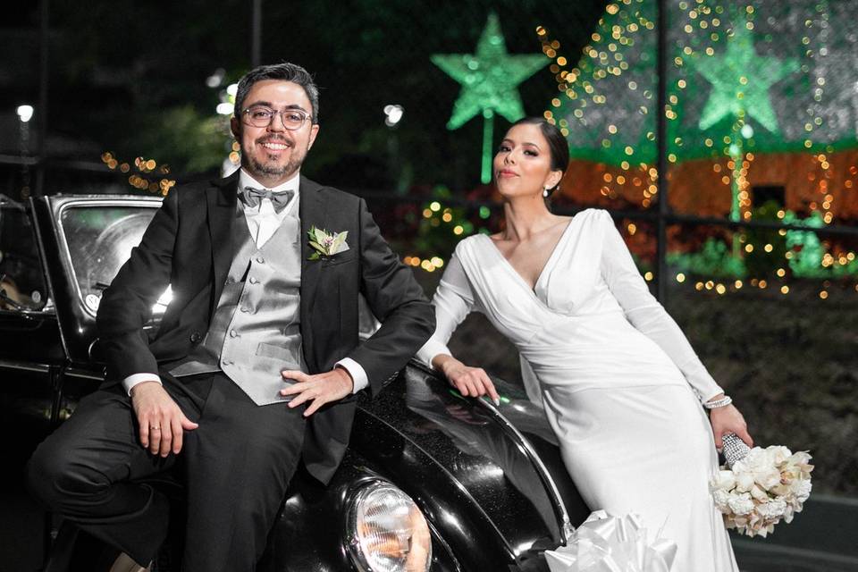 Novios frente a un auto clásico negro