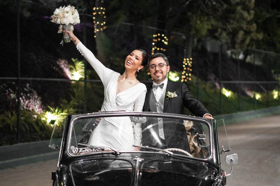 Novios subidos en un auto clásico