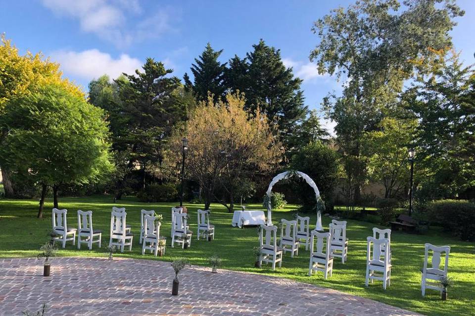 Jardín con sillas blancas